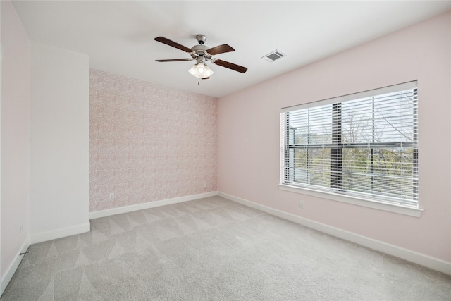 empty room featuring visible vents, baseboards, and carpet floors