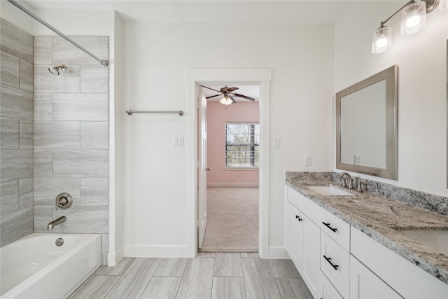 bathroom featuring a sink, shower / bath combination, baseboards, and double vanity