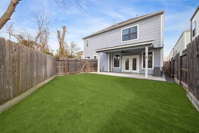 rear view of property featuring a ceiling fan, a patio, french doors, a yard, and central AC unit