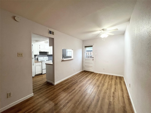 unfurnished living room featuring ceiling fan, wood finished floors, visible vents, and baseboards