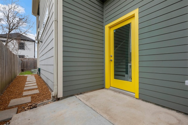 entrance to property with a patio and fence