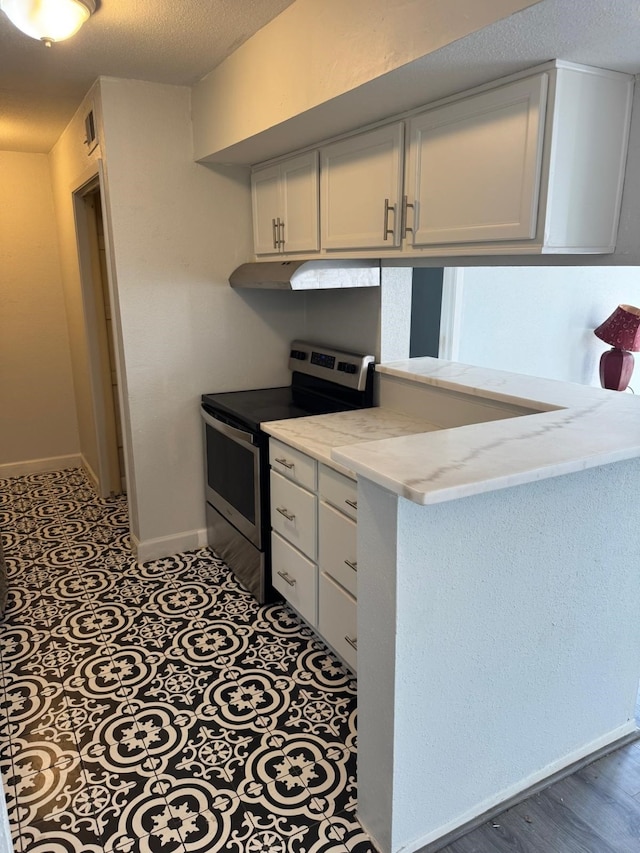 kitchen featuring electric range, baseboards, a peninsula, light stone countertops, and white cabinetry