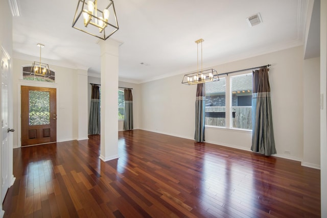 entryway with visible vents, dark wood finished floors, ornamental molding, an inviting chandelier, and ornate columns