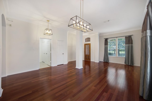 interior space with baseboards, ornamental molding, arched walkways, and dark wood-type flooring