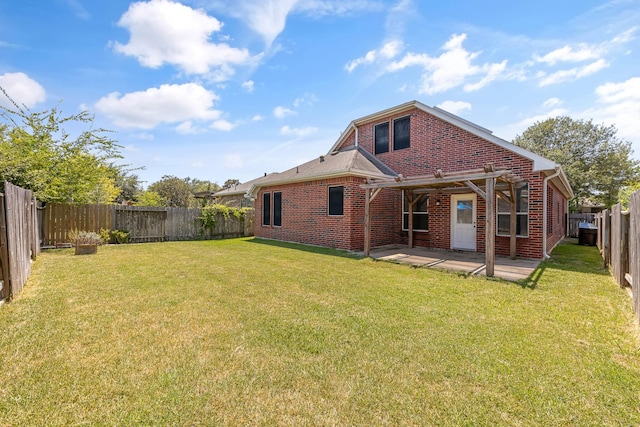 rear view of house featuring a patio area, brick siding, a lawn, and a fenced backyard