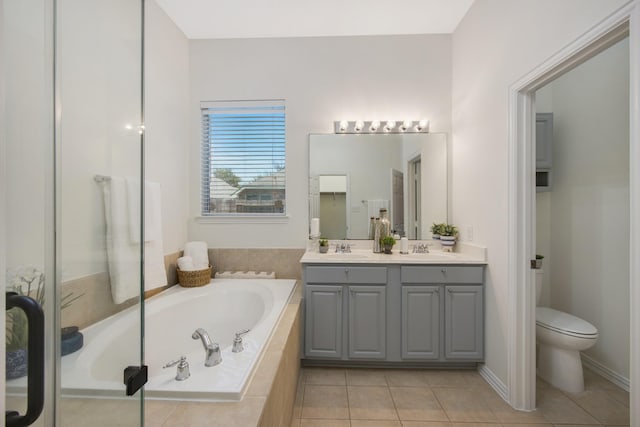 bathroom with tile patterned floors, a sink, toilet, and a bath