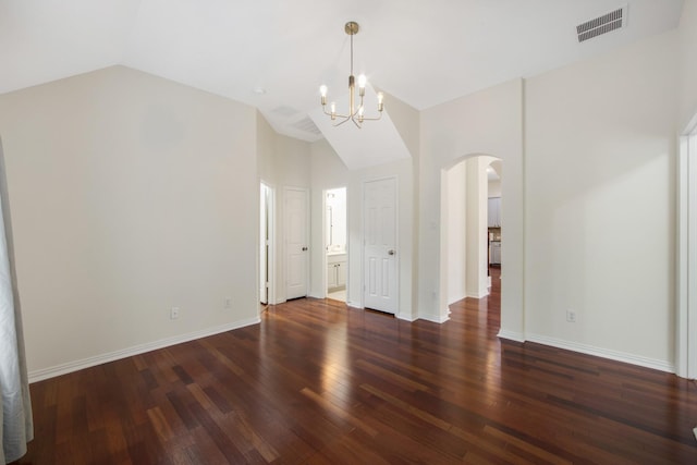 spare room featuring lofted ceiling, arched walkways, visible vents, baseboards, and dark wood-style floors