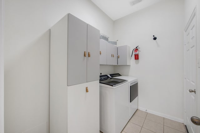 washroom featuring light tile patterned floors, washing machine and dryer, visible vents, baseboards, and cabinet space