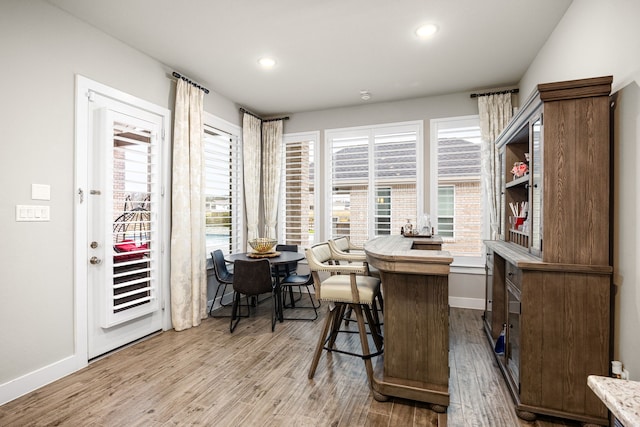 office space featuring a healthy amount of sunlight, light wood-style floors, baseboards, and recessed lighting