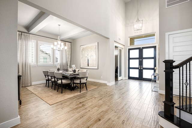 entryway with a chandelier, visible vents, light wood-style floors, and stairway