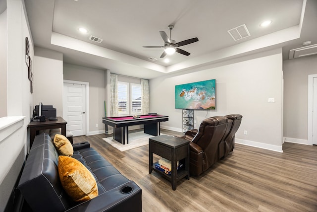 recreation room with baseboards, visible vents, a raised ceiling, and wood finished floors