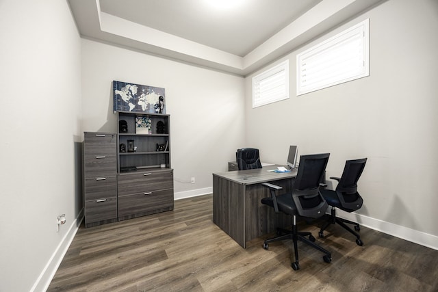 office area featuring a raised ceiling, wood finished floors, and baseboards