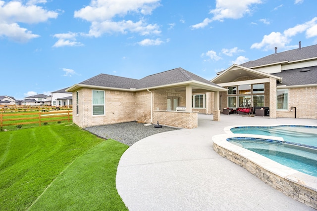 back of house with brick siding, roof with shingles, a patio area, and fence