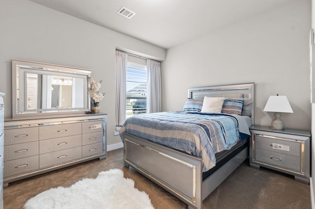 bedroom featuring visible vents, dark carpet, and baseboards