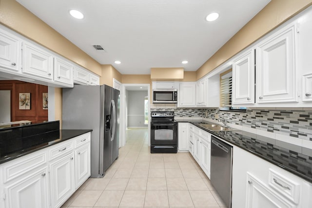 kitchen with light tile patterned floors, decorative backsplash, white cabinets, a sink, and black appliances