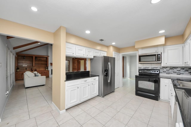 kitchen featuring light tile patterned floors, white cabinetry, appliances with stainless steel finishes, backsplash, and dark countertops