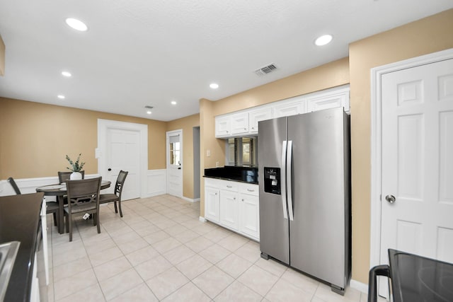 kitchen with light tile patterned floors, recessed lighting, visible vents, white cabinetry, and stainless steel fridge