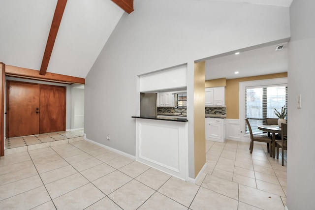 kitchen featuring visible vents, dark countertops, beam ceiling, and white cabinets