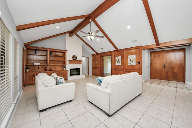 living area with a large fireplace, light tile patterned floors, visible vents, a ceiling fan, and vaulted ceiling with beams