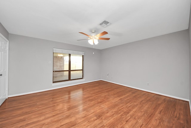 unfurnished room with a ceiling fan, baseboards, visible vents, and wood finished floors