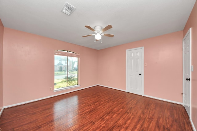 unfurnished room with baseboards, visible vents, ceiling fan, and wood finished floors