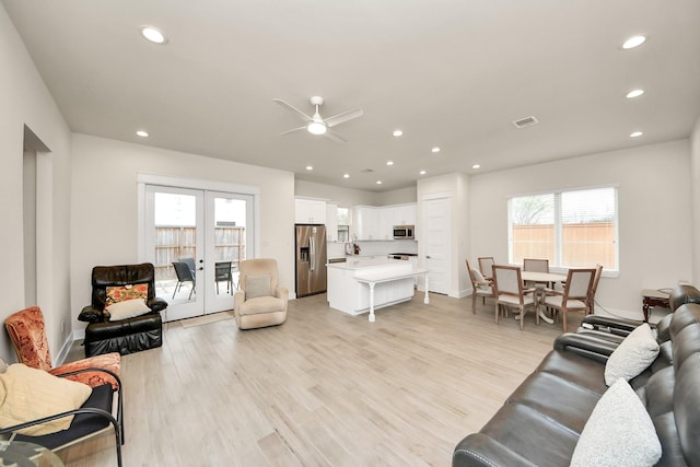 living area with recessed lighting, french doors, visible vents, and light wood-style flooring