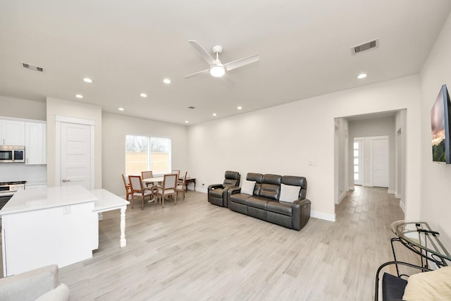 living area featuring light wood finished floors, visible vents, and recessed lighting