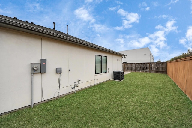 view of yard with central air condition unit and a fenced backyard