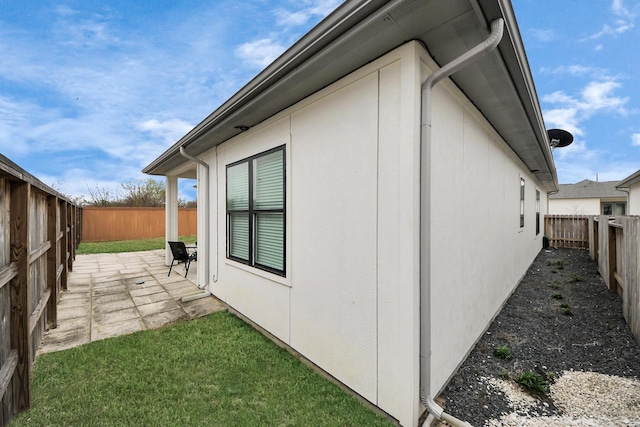 view of side of home featuring a patio and a fenced backyard