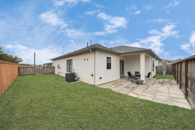 rear view of house with a lawn, a patio, a fenced backyard, central AC, and stucco siding