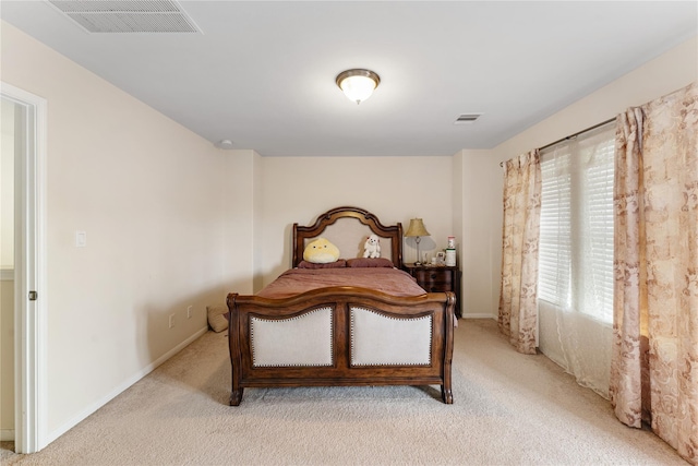 bedroom featuring baseboards, visible vents, and light colored carpet