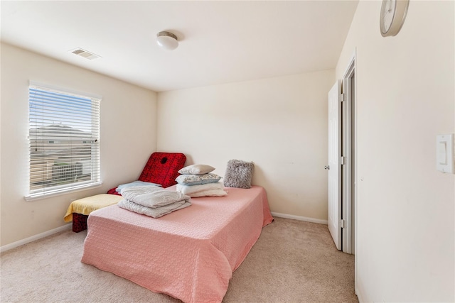 bedroom with light carpet, visible vents, and baseboards