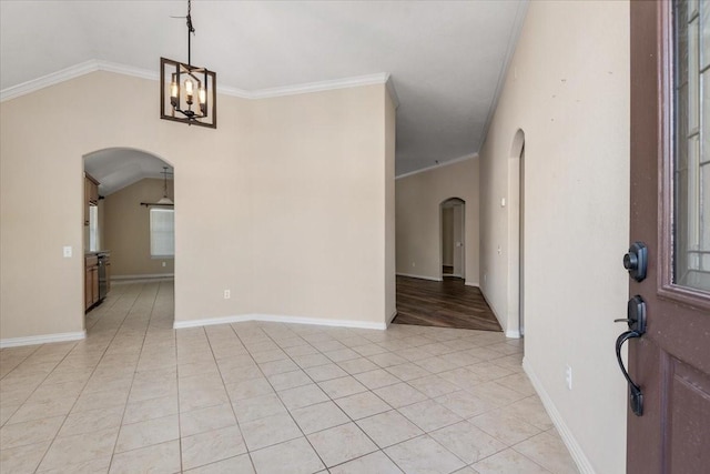 interior space with crown molding, arched walkways, light tile patterned flooring, and vaulted ceiling