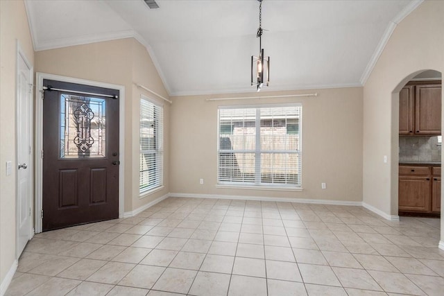 foyer entrance with baseboards, arched walkways, vaulted ceiling, crown molding, and light tile patterned flooring