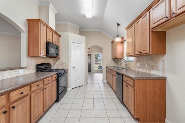 kitchen with arched walkways, dark countertops, hanging light fixtures, black appliances, and a sink