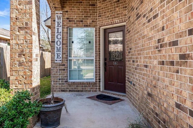 doorway to property featuring a patio area and brick siding