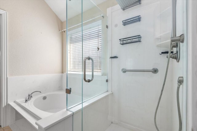 bathroom with a garden tub and a shower with door