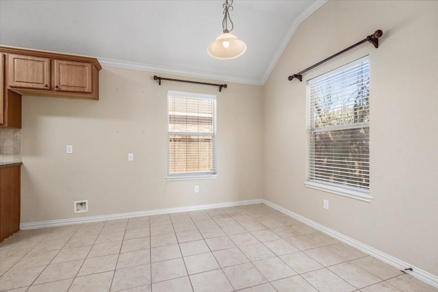 interior space with ornamental molding, vaulted ceiling, baseboards, and light tile patterned floors