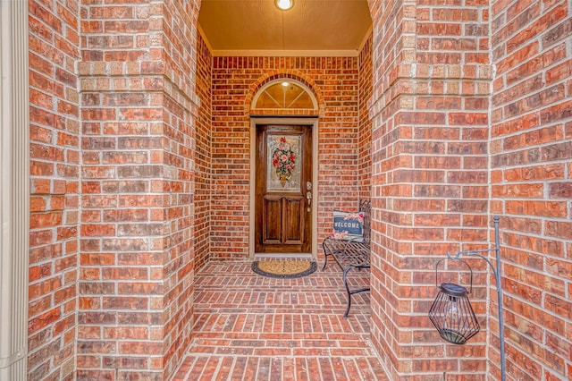 view of exterior entry with brick siding