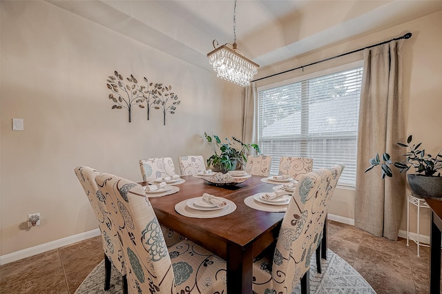 tiled dining space with a notable chandelier and baseboards