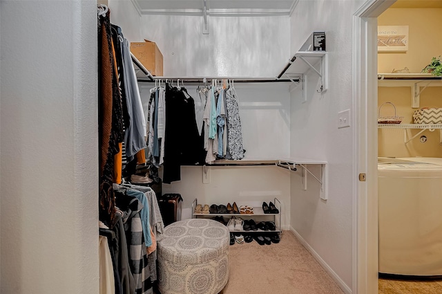 spacious closet featuring washer / clothes dryer and light colored carpet