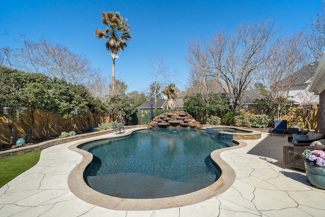 view of pool featuring a patio area, a fenced backyard, and a pool with connected hot tub