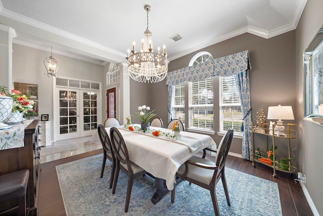 dining room with a chandelier, visible vents, dark wood finished floors, and crown molding