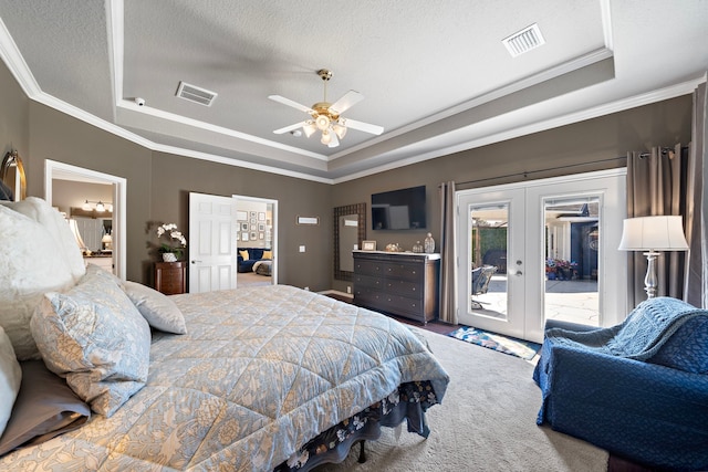 bedroom featuring access to exterior, a tray ceiling, french doors, and visible vents