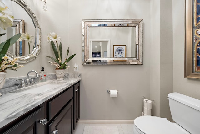 bathroom featuring toilet, tile patterned floors, baseboards, and vanity