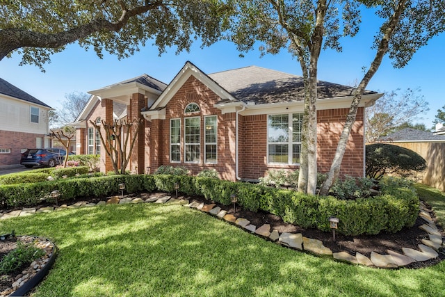 view of front of home featuring a front lawn and brick siding