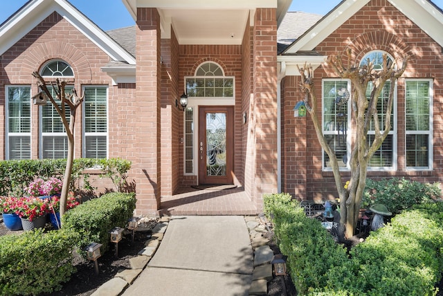 property entrance with brick siding and roof with shingles