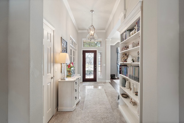 foyer entrance featuring a notable chandelier, baseboards, and crown molding