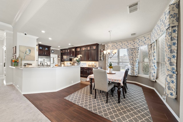 dining space with a chandelier, visible vents, crown molding, and dark wood-style floors