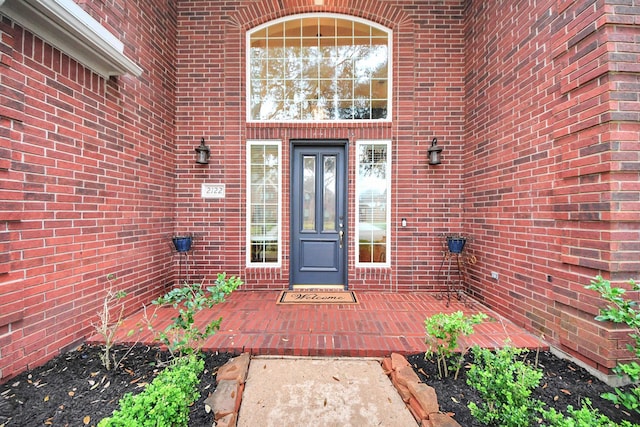 entrance to property featuring brick siding